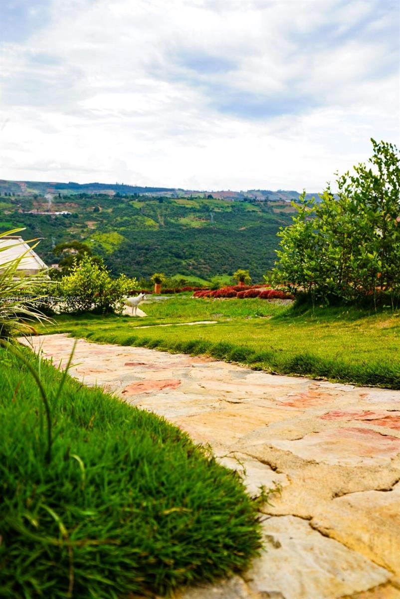 A stone path leads through a grassy lawn toward a scenic mountain landscape — 123 Curiti, 684031, FL