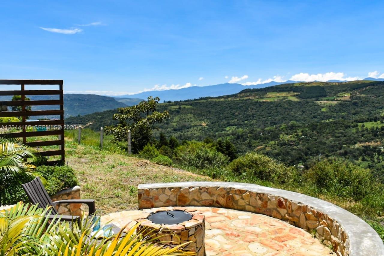 A stone fire pit sits on a patio overlooking a vast mountain landscape — 123 Curiti, 684031, FL