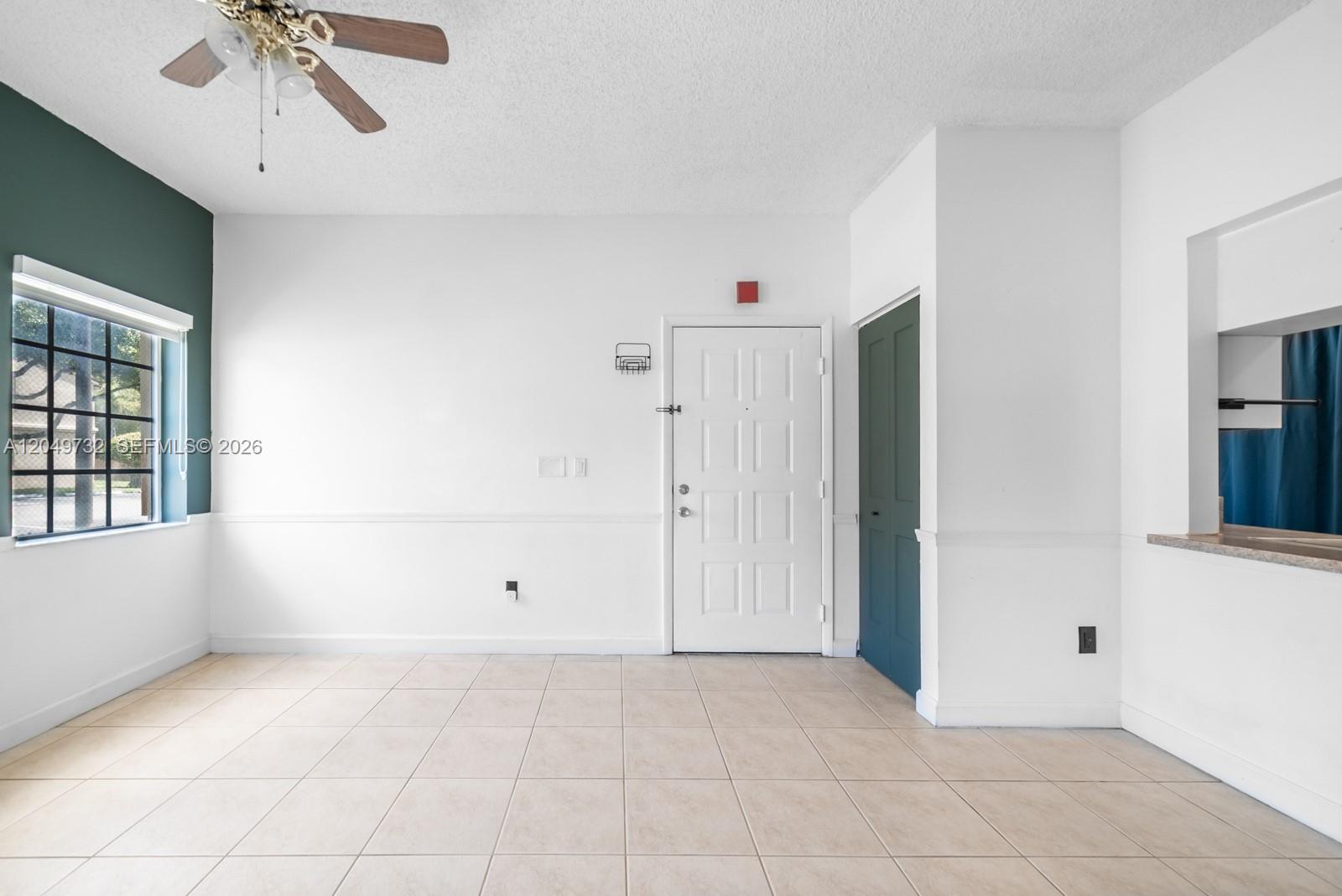 This room features white walls, tile flooring, a ceiling fan, and a white entry door — 18308 NW 68th Ave # B, Hialeah FL 33015, HIALEAH, FL