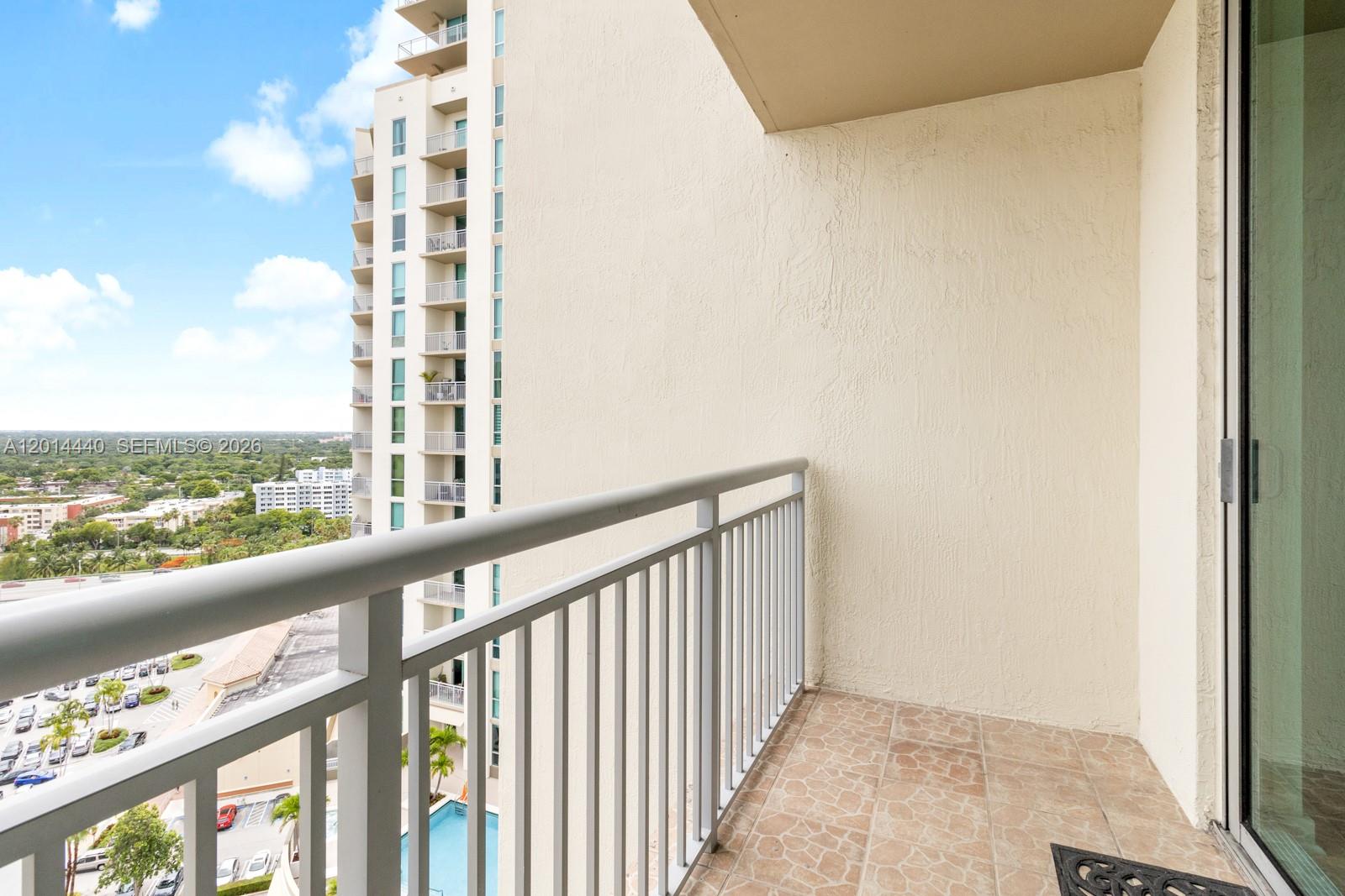 A high-rise balcony features a metal railing, tiled flooring, and a view of neighboring buildings — 9055 SW 73rd Ct # 1506, Miami FL 33156, MIAMI, FL