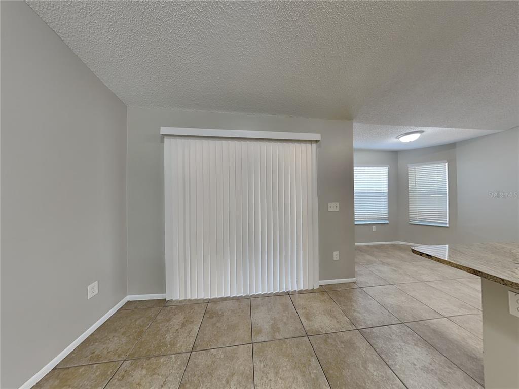 A room with tiled floors, a sliding glass door with vertical blinds, and two windows — 1488 COUNTRY MANSION COURT, APOPKA, FL
