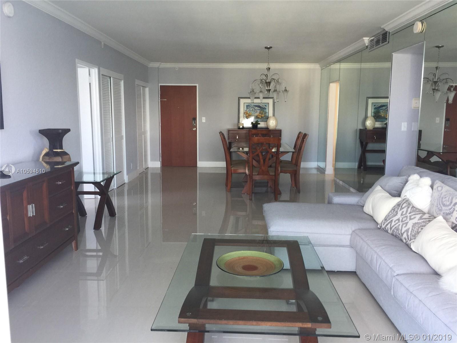 A living and dining room area features light gray walls, tile flooring, and mirrored walls — 3901 S Ocean Dr # 14E, Hollywood FL 33019, HOLLYWOOD, FL