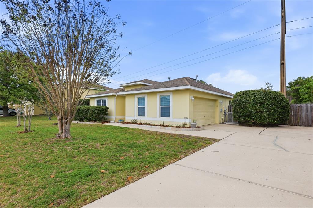 A single-story yellow house with a two-car garage and a concrete driveway — 23152 NW 11TH ROAD, NEWBERRY, FL