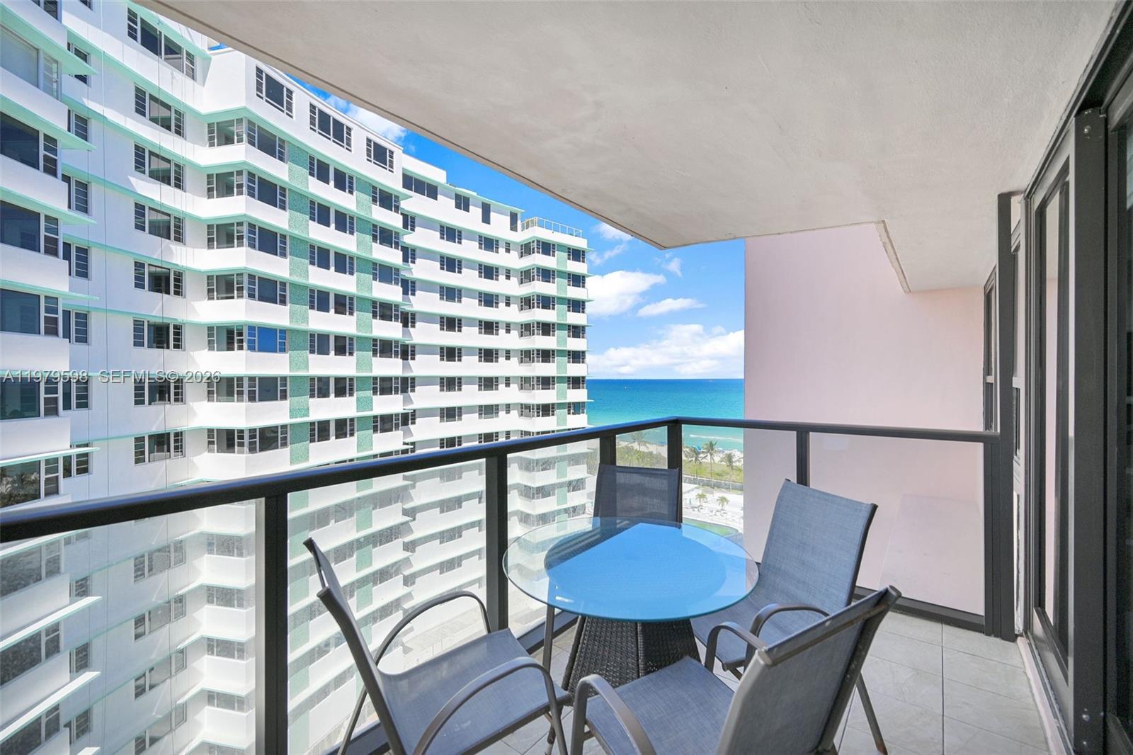 An aerial view shows several high-rise apartment buildings situated along a sandy beach — 5225 Collins Ave # 1214, Miami Beach FL 33140, MIAMI BEACH, FL
