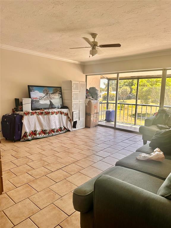 A living room with tile flooring, a ceiling fan, and a sliding door to a patio — 2948 CLARK BOULEVARD UNIT 224, SARASOTA, FL