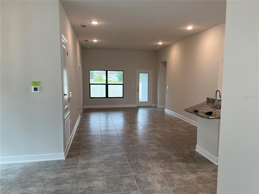 An open-concept living area with tile flooring, recessed lighting, and a kitchen island — 132 BERGAMOT LOOP, DAVENPORT, FL