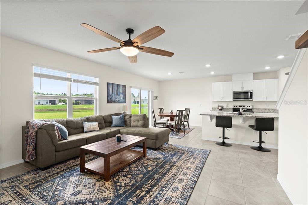An open-concept living room and kitchen with a sectional sofa, dining area, and breakfast bar — 1317 MIDDLE LAKE DRIVE, ORMOND BEACH, FL