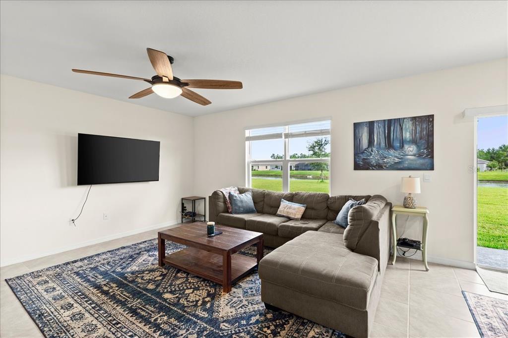 A living room features a sectional sofa, a coffee table, a rug, and a television — 1317 MIDDLE LAKE DRIVE, ORMOND BEACH, FL