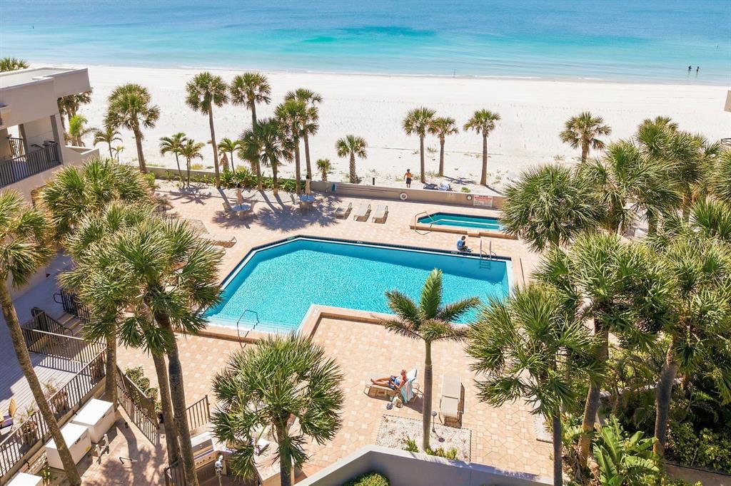 An aerial view of a resort swimming pool and hot tub located beside a sandy beach — 1600 GULF BOULEVARD UNIT 817, CLEARWATER BEACH, FL