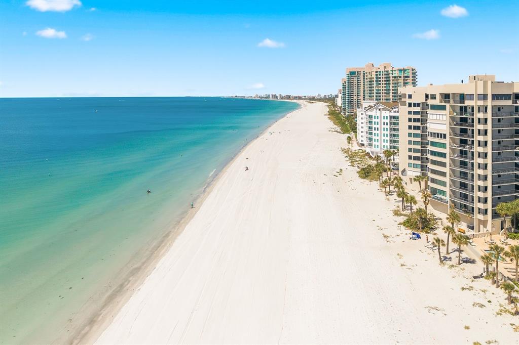An aerial view of a white sand beach next to high-rise oceanfront apartment buildings — 1600 GULF BOULEVARD UNIT 817, CLEARWATER BEACH, FL