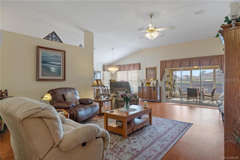 A living room with wood flooring, a ceiling fan, and sliding doors to a patio — 4658 N LAKE VISTA TRAIL, HERNANDO, FL