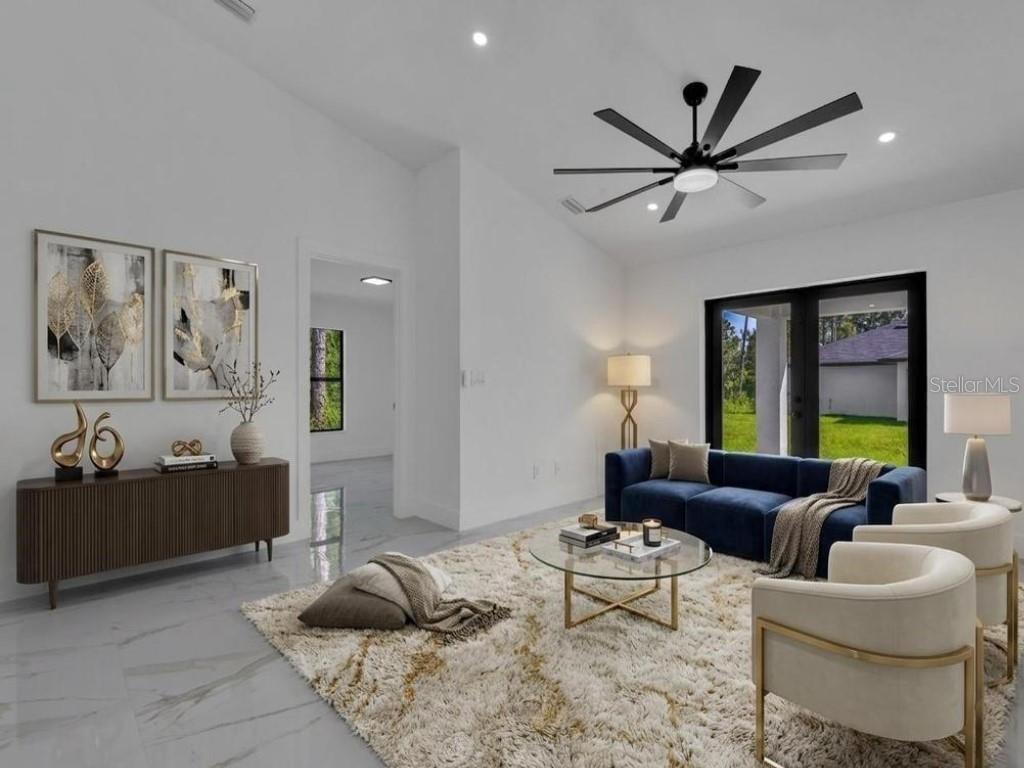 A modern living room features a blue sofa, white armchairs, a glass coffee table, and tile flooring — 4745 13TH STREET SW, LEHIGH ACRES, FL