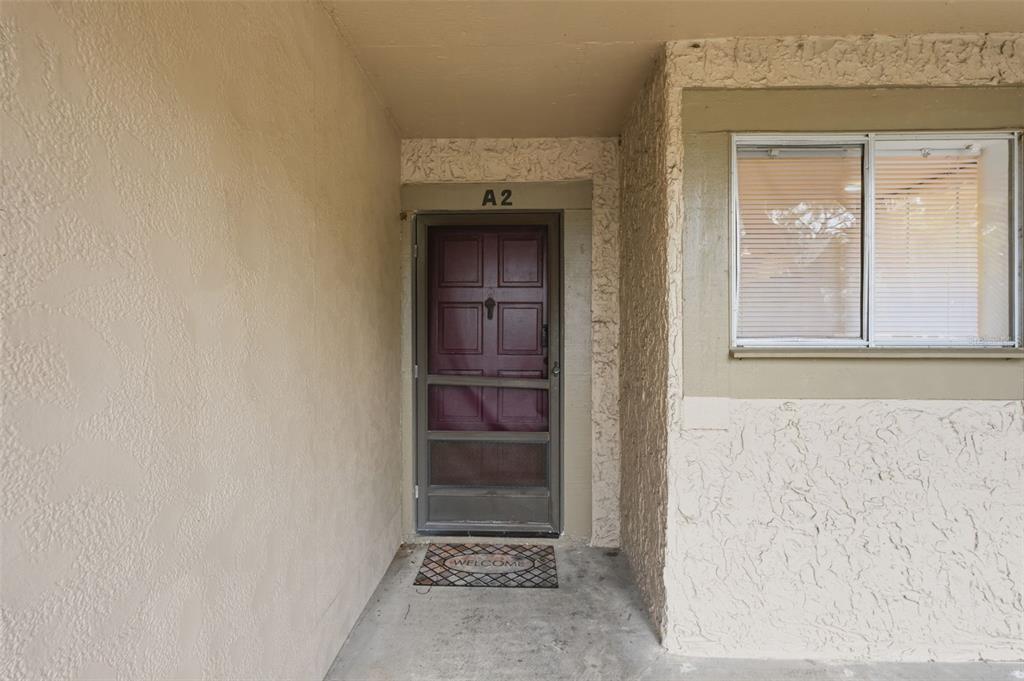 A front entrance features a maroon door with a screen door and a welcome mat — 6340 NEWTOWN CIRCLE UNIT 40A2, TAMPA, FL