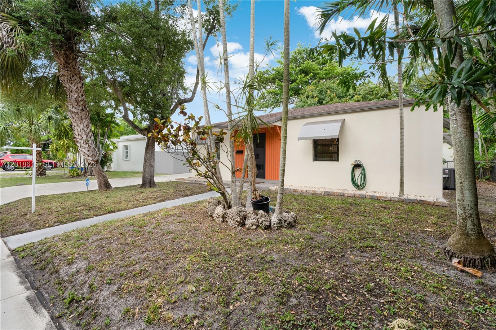 A single-story house with a light-colored exterior, orange front door, and palm trees — 6531 SW 57th Pl, South Miami FL 33143, SOUTH MIAMI, FL