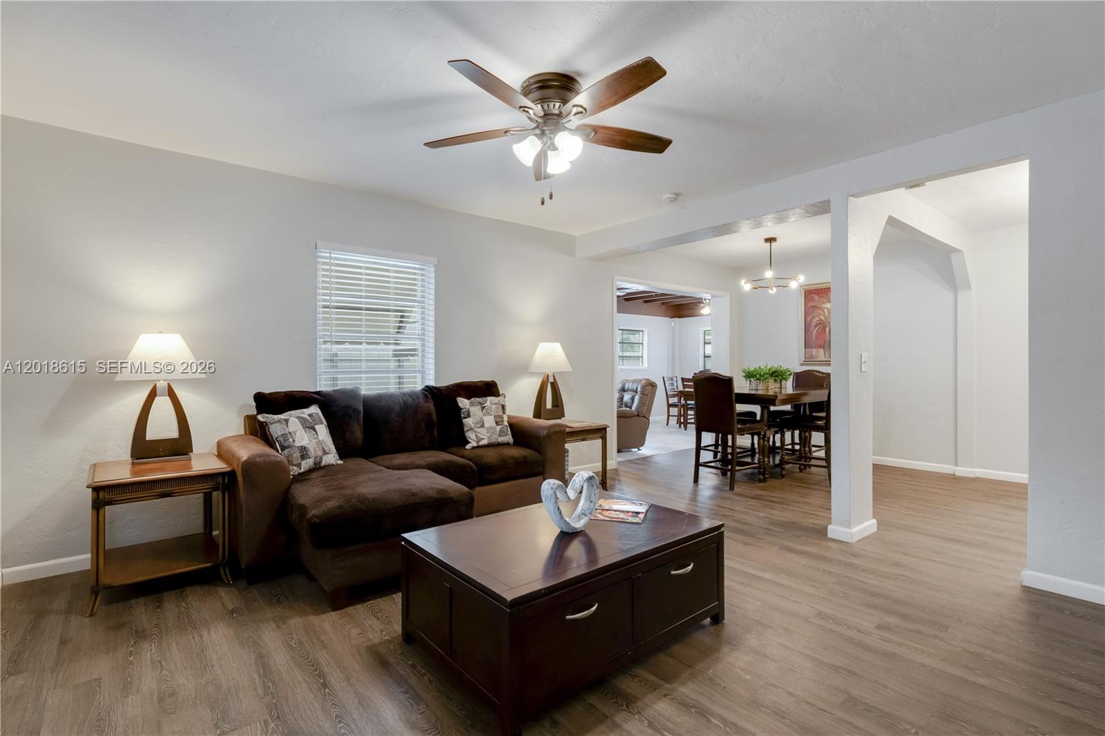 A living room with a brown sectional sofa and coffee table opens to a dining area — 6531 SW 57th Pl, South Miami FL 33143, SOUTH MIAMI, FL