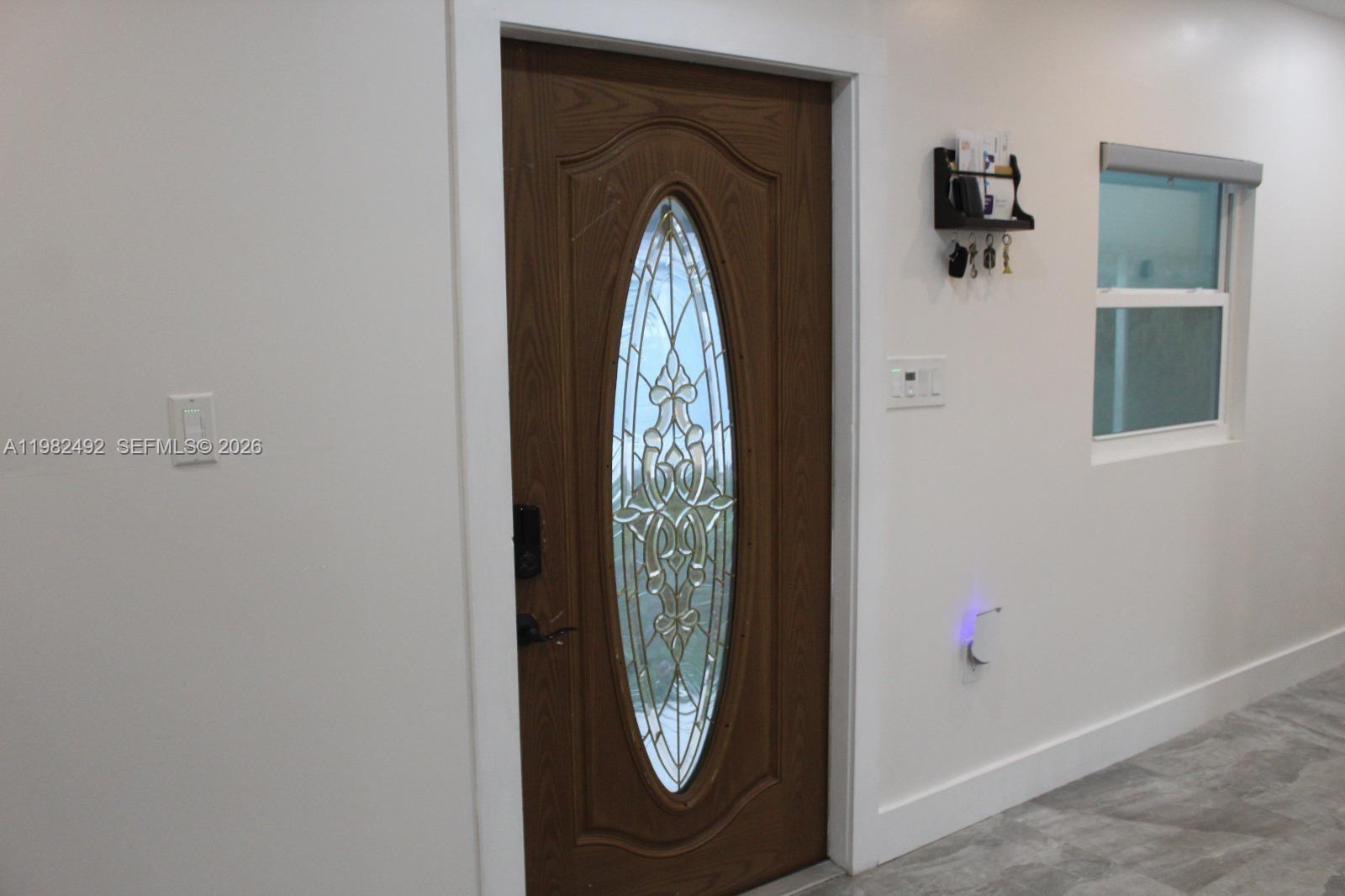 An interior view shows a wooden front door with a decorative oval glass insert — 115 SW 115th Ave, Miramar FL 33025, MIRAMAR, FL