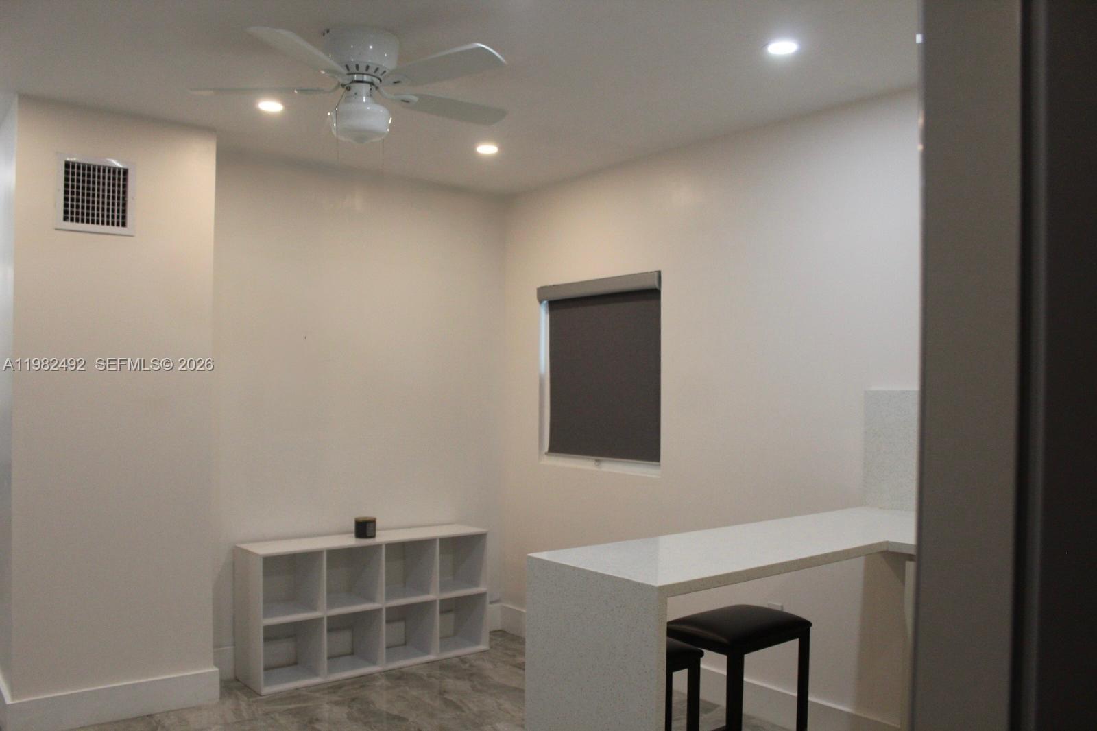 A room with white walls, a ceiling fan, a storage unit, and a breakfast bar — 115 SW 115th Ave, Miramar FL 33025, MIRAMAR, FL