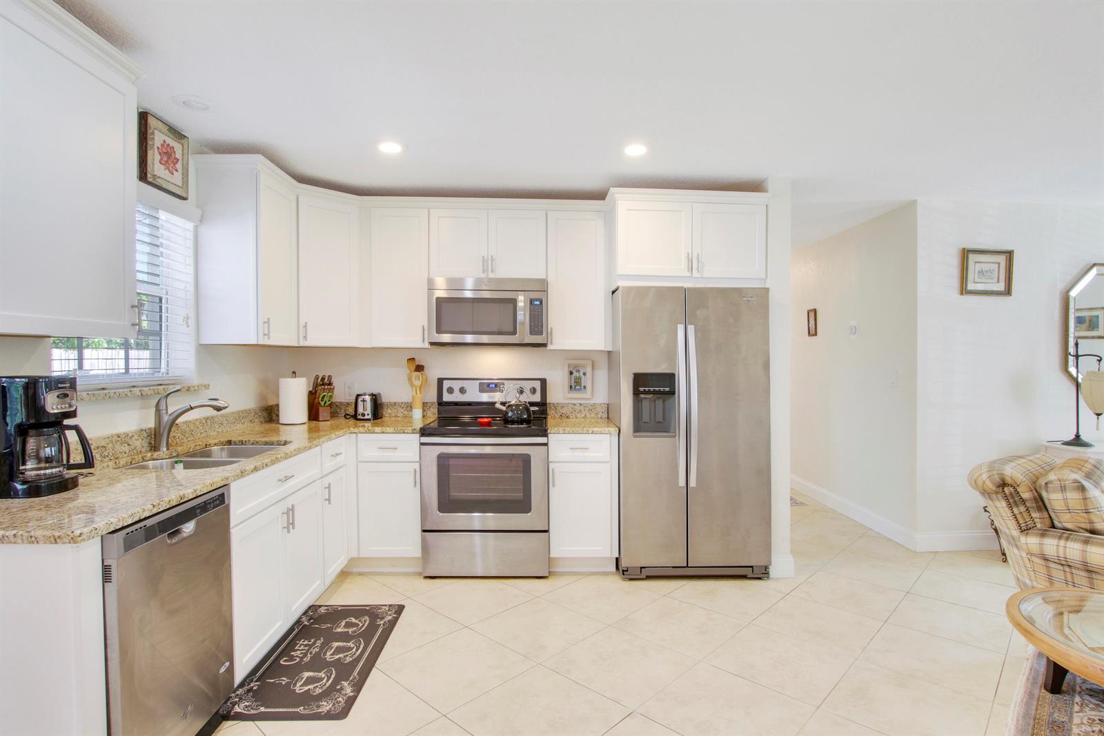A kitchen with white cabinets, stainless steel appliances, and granite countertops — 19185 SE Homewood Avenue, Jupiter FL 33469, JUPITER, FL