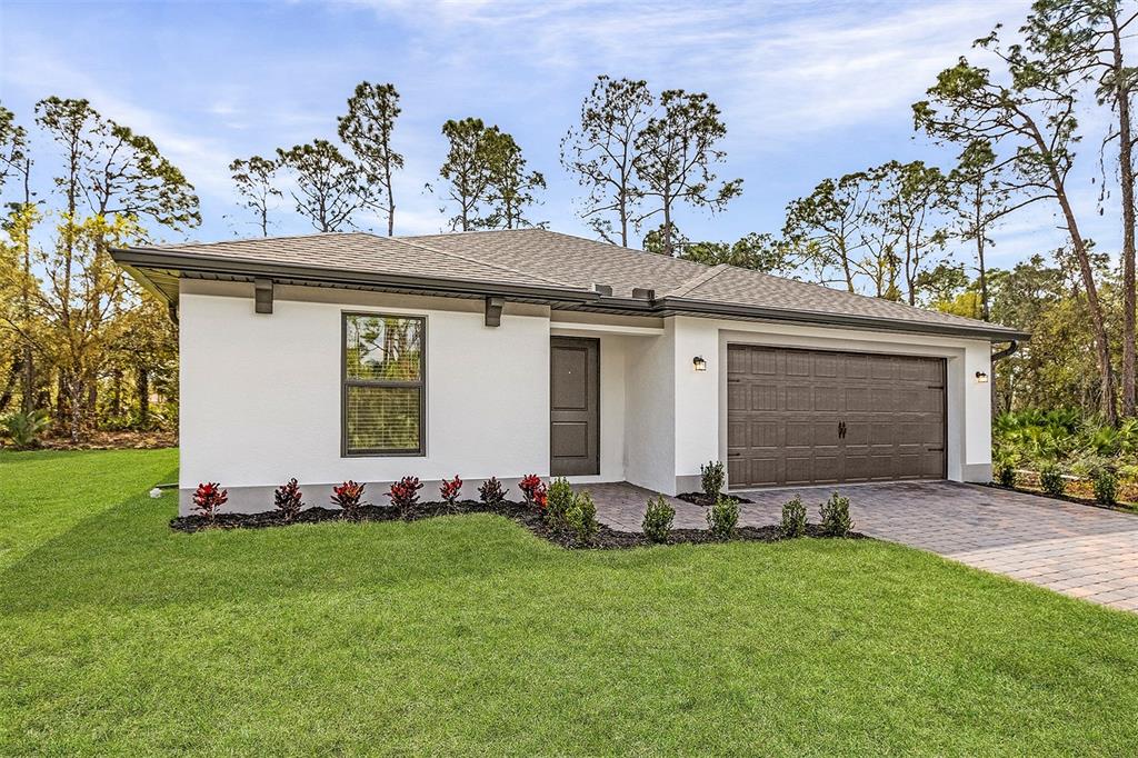 A single-story house with white stucco walls, a dark garage door, and a paved driveway — 4081 LONGWELL LANE, NORTH PORT, FL