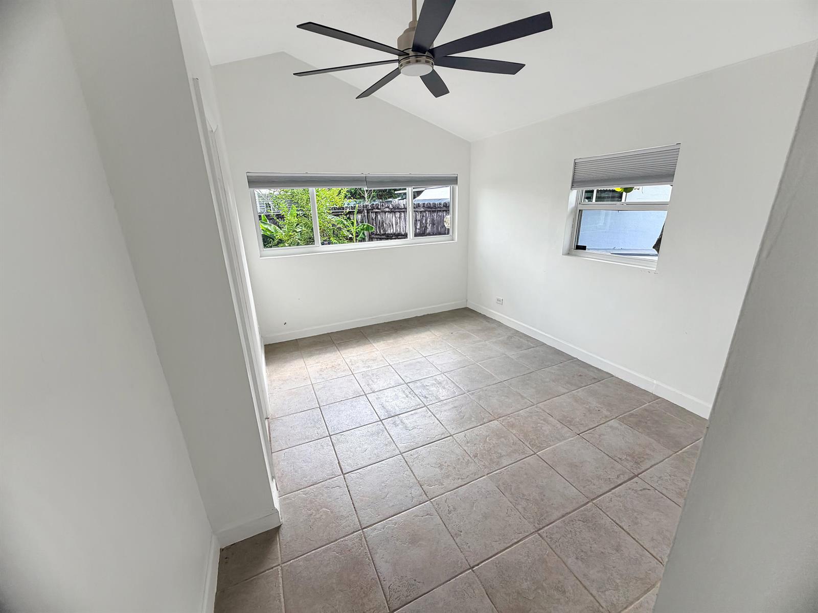 An empty room with white walls, tile flooring, a vaulted ceiling, and a ceiling fan — 752 Orchid Drive, Royal Palm Beach FL 33411, ROYAL PALM BEACH, FL
