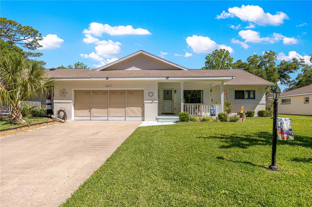 A single-story house with a beige exterior, a two-car garage, and a front porch — 8671 SW 97TH STREET UNIT G, OCALA, FL