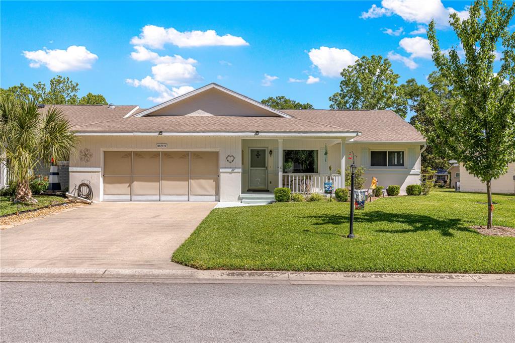 A single-story house with a two-car garage, a covered front porch, and a grassy lawn — 8671 SW 97TH STREET UNIT G, OCALA, FL