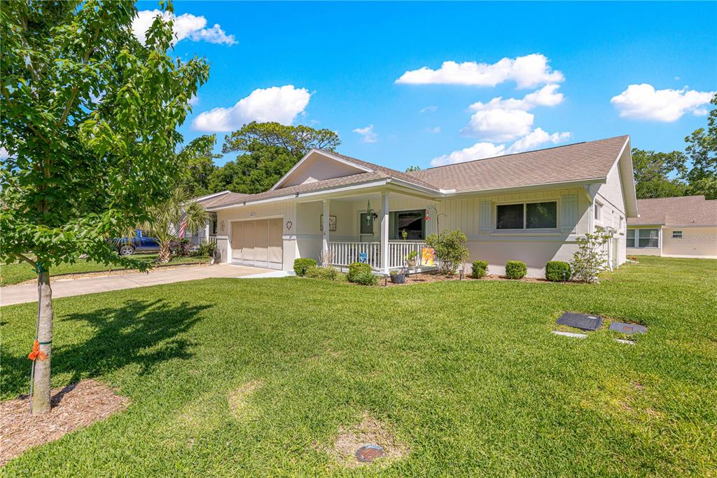 A single-story house with a white exterior, a front porch, and a paved driveway — 8671 SW 97TH STREET UNIT G, OCALA, FL