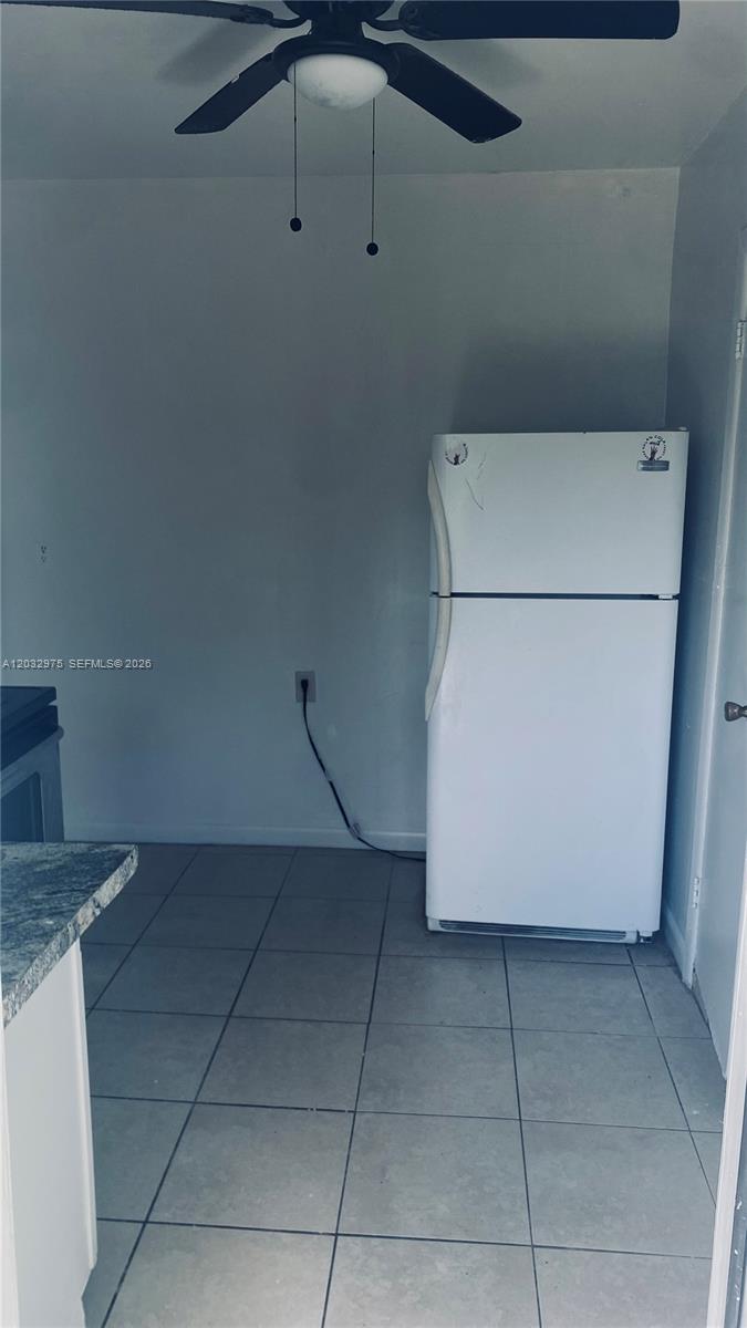 A white refrigerator stands in a kitchen with tiled floors and a ceiling fan — 1070 NW 147th St # 0, Miami FL 33168, MIAMI, FL