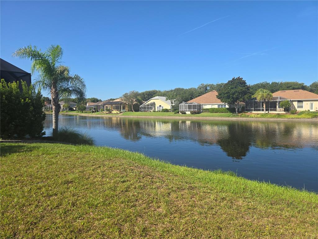 A view of a lake behind several residential houses with screened-in lanais — 86 FRONT STREET, PALM COAST, FL