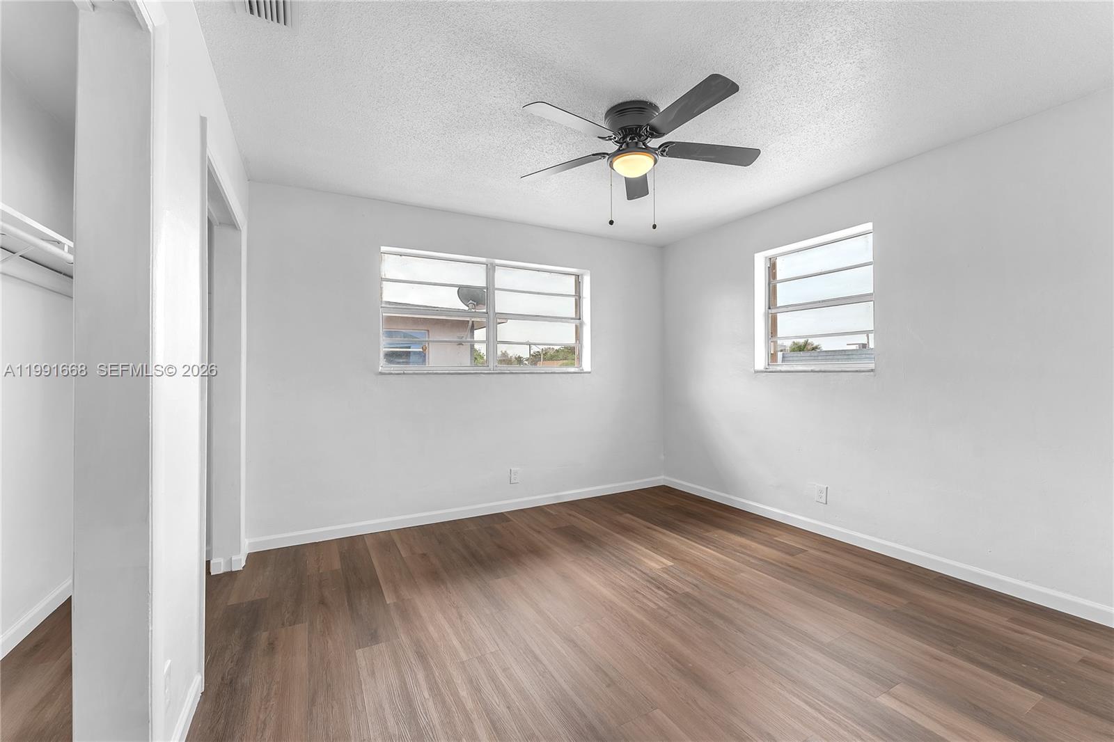 An empty bedroom features light gray walls, wood-look flooring, and a ceiling fan — 3750 SW 59th Ave # 3, Davie FL 33314, DAVIE, FL