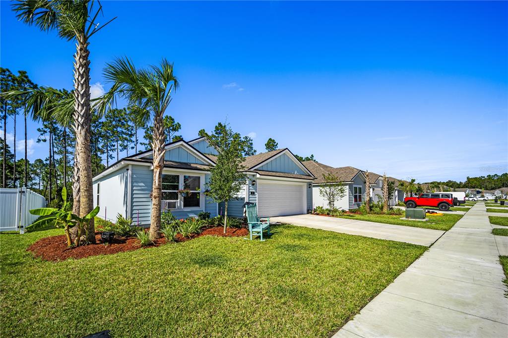 A light blue single-story house with a two-car garage and a front lawn — 14 LUMBER JACK TRAIL, PALM COAST, FL