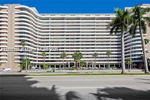 A large, multi-story residential building with curved balconies and palm trees in front — 5555 Collins Ave # 14U, Miami Beach FL 33140, MIAMI BEACH, FL