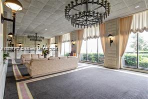 A spacious, carpeted lounge area features a large sofa, ornate chandeliers, and floor-to-ceiling windows — 5555 Collins Ave # 14U, Miami Beach FL 33140, MIAMI BEACH, FL