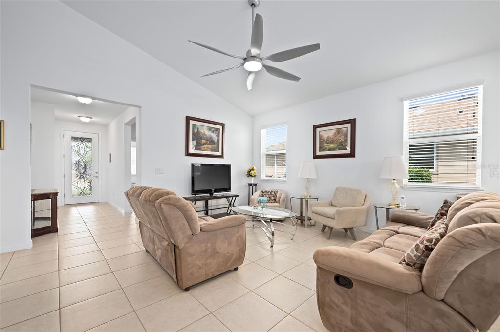 A living room features light tile flooring, two brown recliners, and a ceiling fan — 5610 NW 37TH LANE ROAD, OCALA, FL