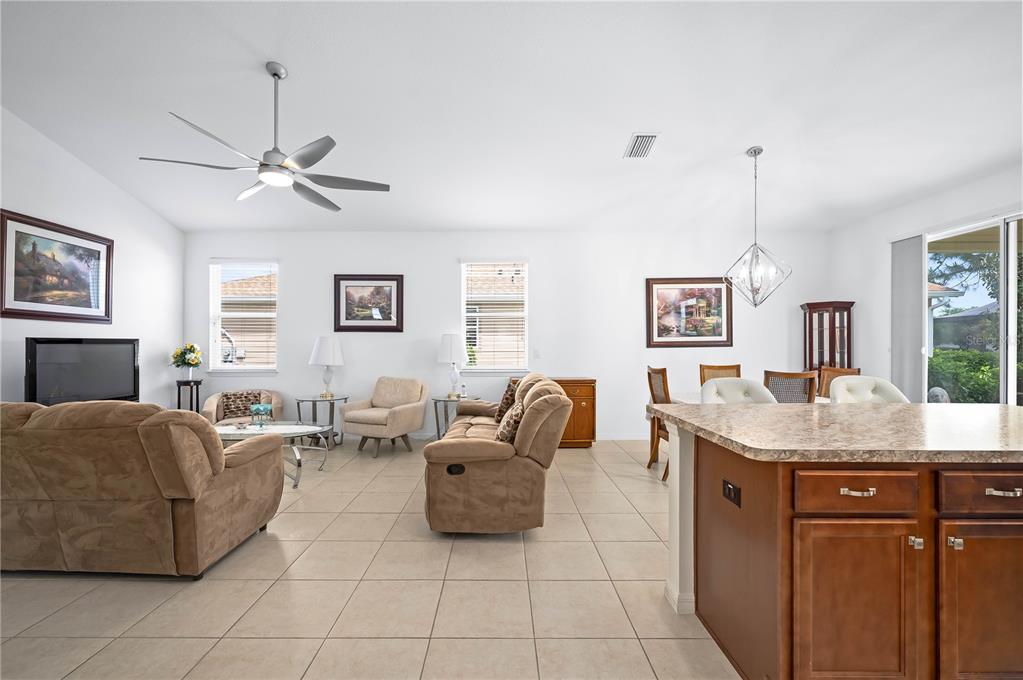 An open-concept living and dining area features tile flooring, neutral walls, and wood cabinetry — 5610 NW 37TH LANE ROAD, OCALA, FL