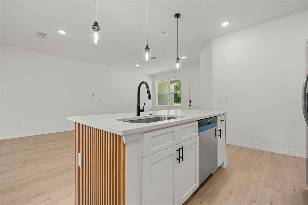 A kitchen island with a white countertop and wood-slat detailing sits in a bright room — 1197 W G MARTINELLI BOULEVARD, CITRUS SPRINGS, FL