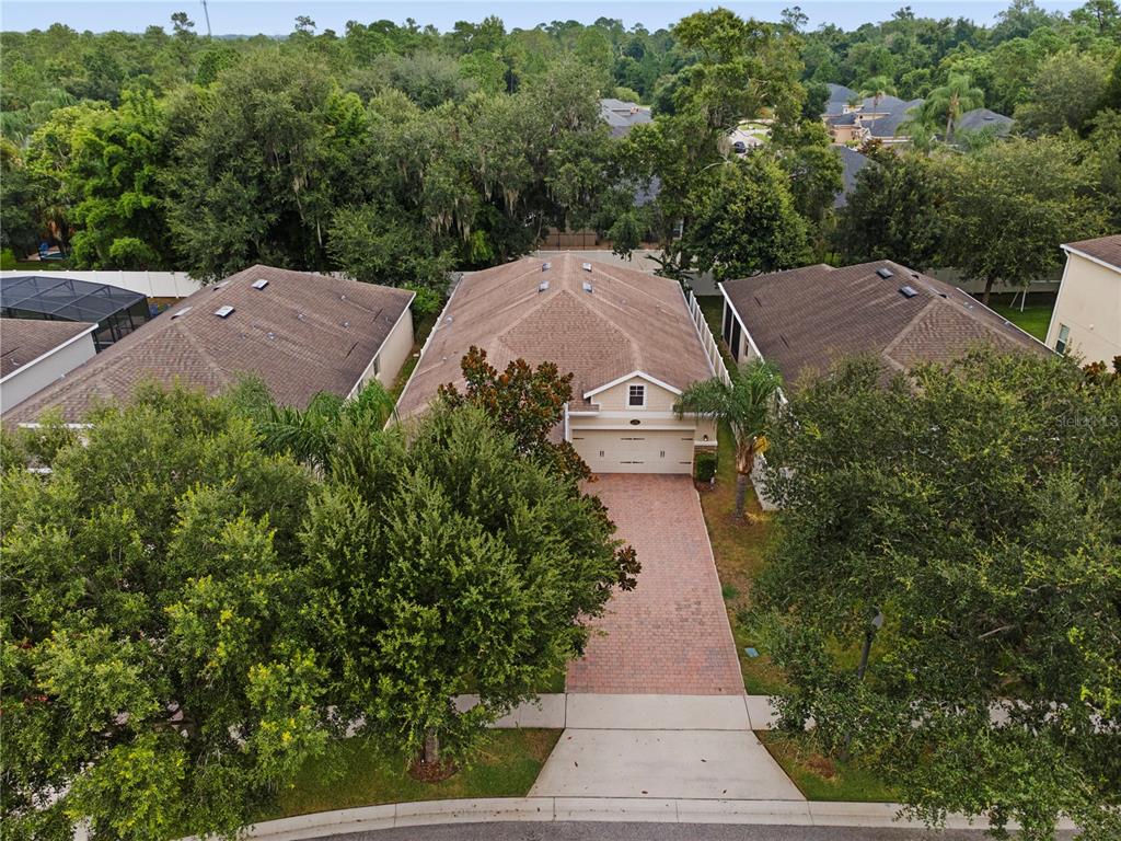 An aerial view shows a single-story house with a brick driveway and a brown roof — 2651 PEONY DRIVE, OVIEDO, FL