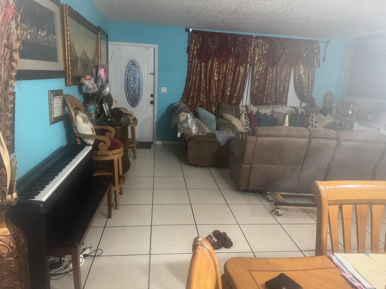 A living room features light blue walls, tile flooring, a piano, and brown furniture — 6218 NW 17th Street, Margate FL 33063, MARGATE, FL