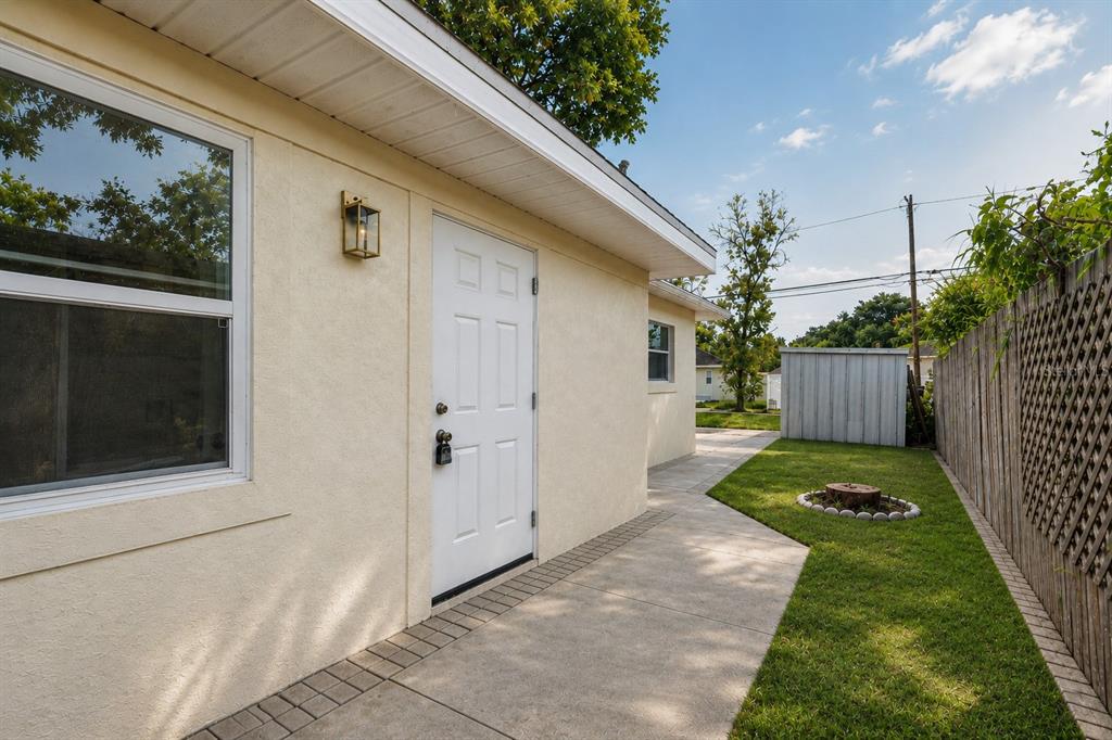 A white door and window are on the side of a stucco house with a walkway — 5532 6TH AVENUE N, ST PETERSBURG, FL
