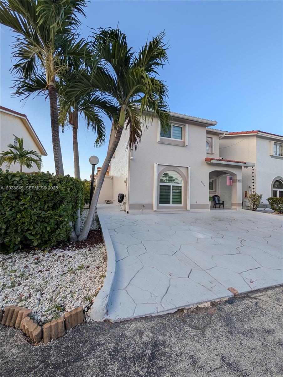 A two-story house with a paved driveway, palm trees, and a hedge in the front yard — 8275 NW 186th St # 801, Hialeah FL 33015, HIALEAH, FL