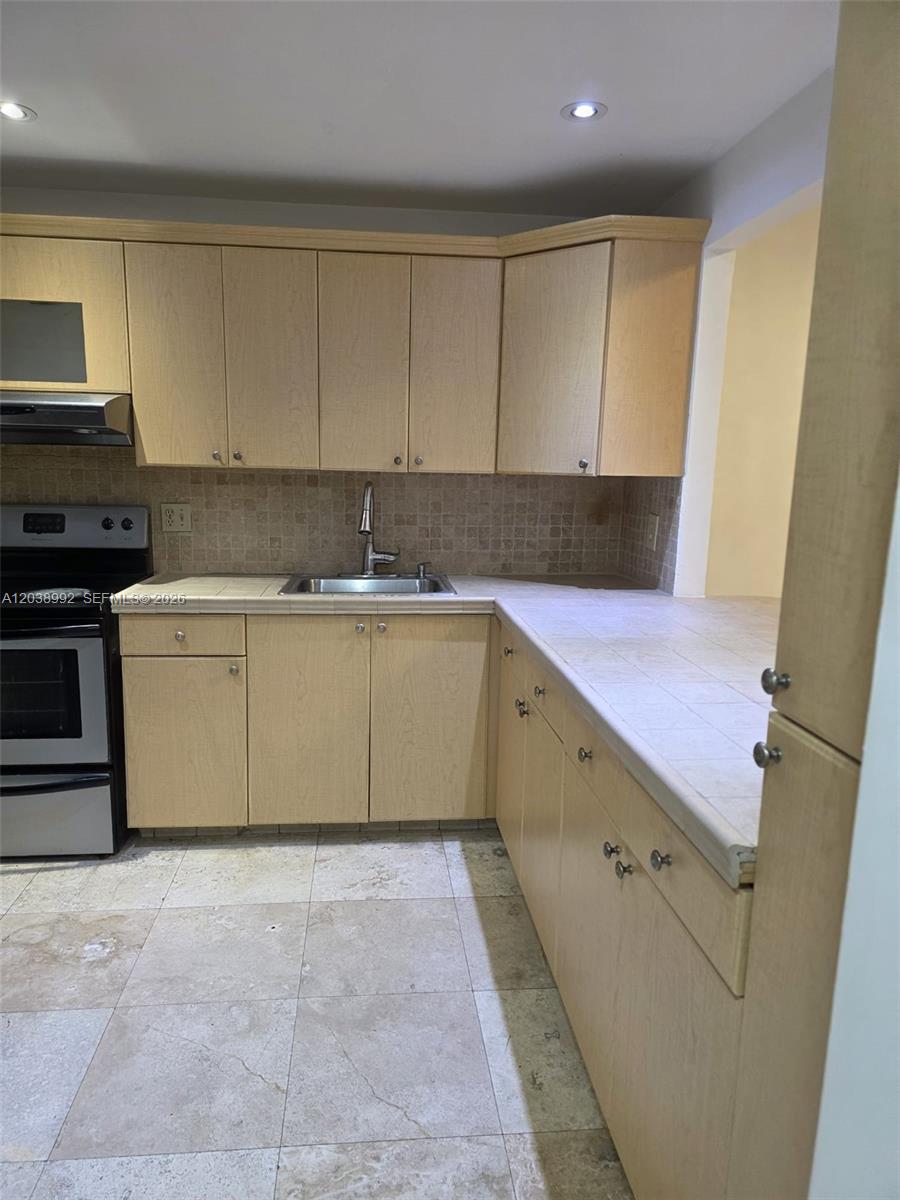 A kitchen features light wood cabinets, a tiled backsplash, and a tiled countertop — 1817 S Ocean Dr # 18, Hallandale Beach FL 33009, HALLANDALE BEACH, FL