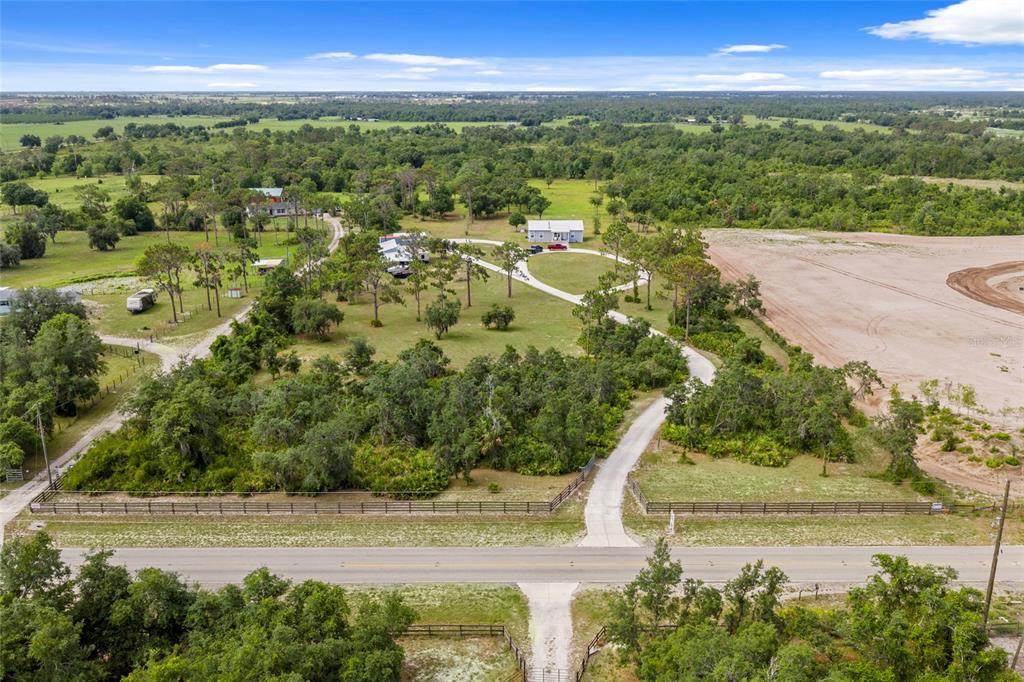 An aerial view shows a rural property with a house, outbuildings, and a long driveway — 34452 SINGLETARY RD, MYAKKA CITY, FL
