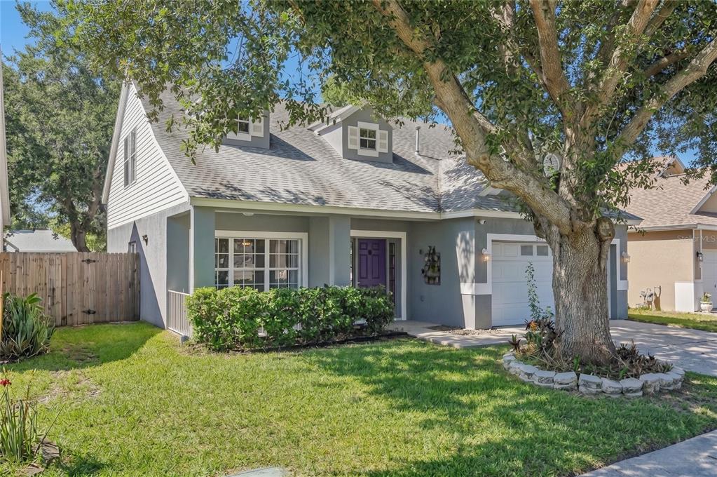 A two-story house with a gray exterior, a purple front door, and a large front tree — 24348 SUMMER WIND COURT, LUTZ, FL