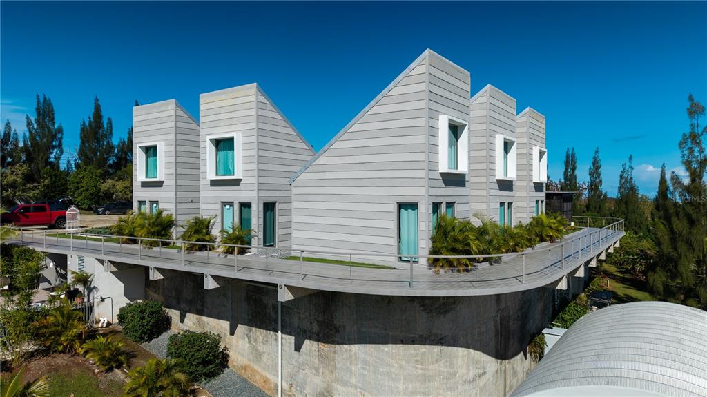 An elevated, modern house with gray horizontal siding and a curved balcony sits on a concrete base — 0 "CARRETERA 308 BARRIO MIRADERO", CABO ROJO, PR
