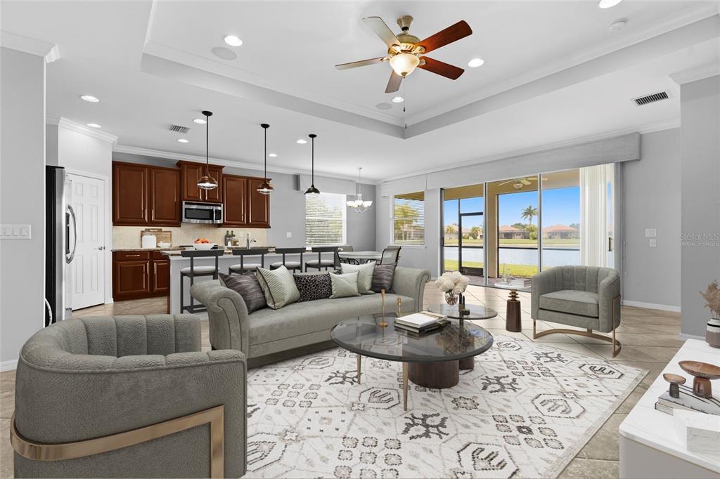 A living room and kitchen open-concept space featuring dark wood cabinets and a lake view — 7360 TALON BAY DRIVE, NORTH PORT, FL