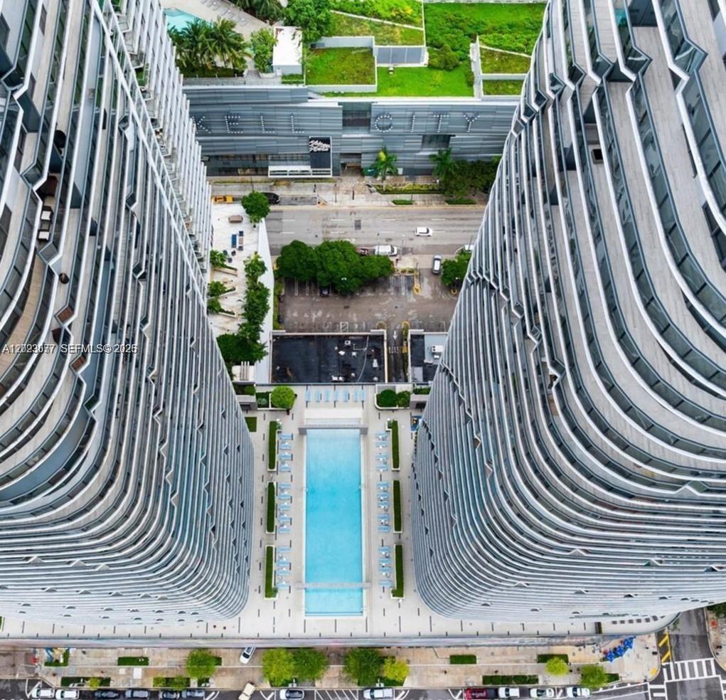 An aerial view shows a swimming pool situated between two tall, modern residential towers — 45 SW 9th St # 3501, Miami FL 33130, MIAMI, FL