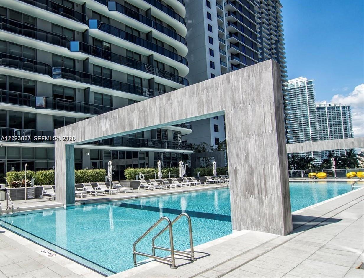 A swimming pool features a large concrete archway structure on a modern apartment building deck — 45 SW 9th St # 3501, Miami FL 33130, MIAMI, FL