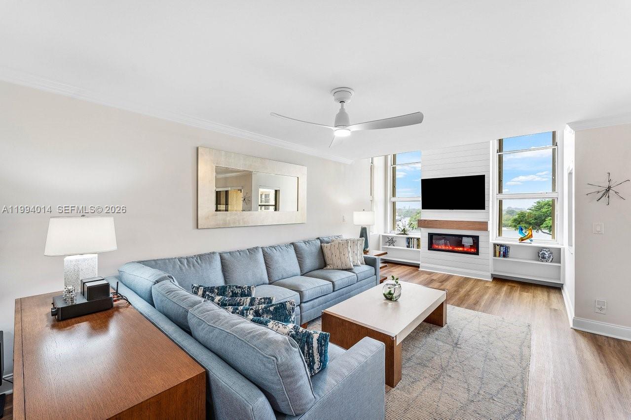 A living room features a blue sectional sofa, a fireplace, and large windows — 364 Golfview Rd # 505, North Palm Beach FL 33408, NORTH PALM BEACH, FL