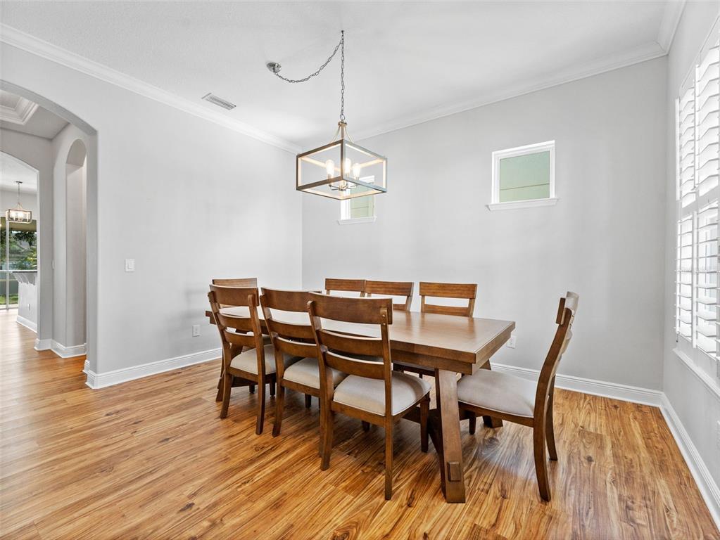 A dining room features a wooden table with six chairs under a rectangular pendant light — 7606 S SPARKMAN STREET, TAMPA, FL