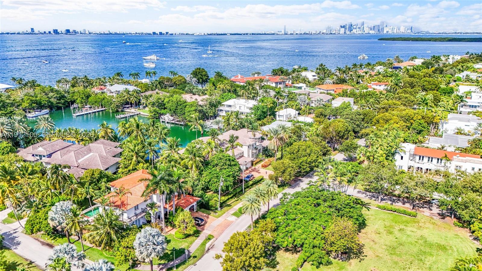 An aerial view of a waterfront house with a pool, dock, and several moored boats — 550 Harbor Dr, Key Biscayne FL 33149, KEY BISCAYNE, FL
